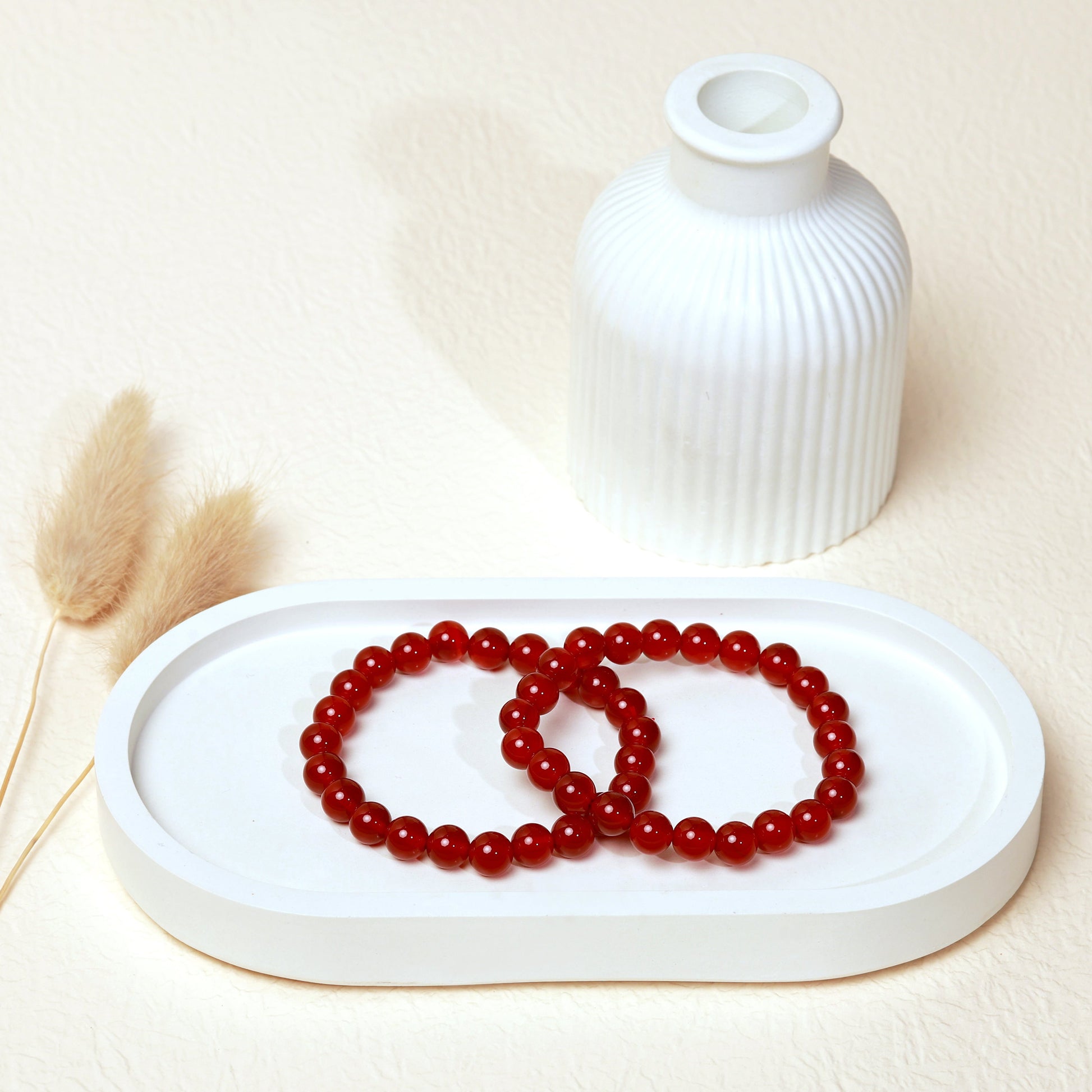 Lifestyle shot of Carnelian bracelets, featuring the warm, vibrant reddish orange hues of the crystals.