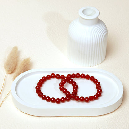 Lifestyle shot of Carnelian bracelets, featuring the warm, vibrant reddish orange hues of the crystals.