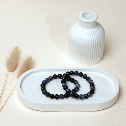 Lifestyle shot of Sodalite bracelets, featuring the deep blue and white marbled hues of the crystals.